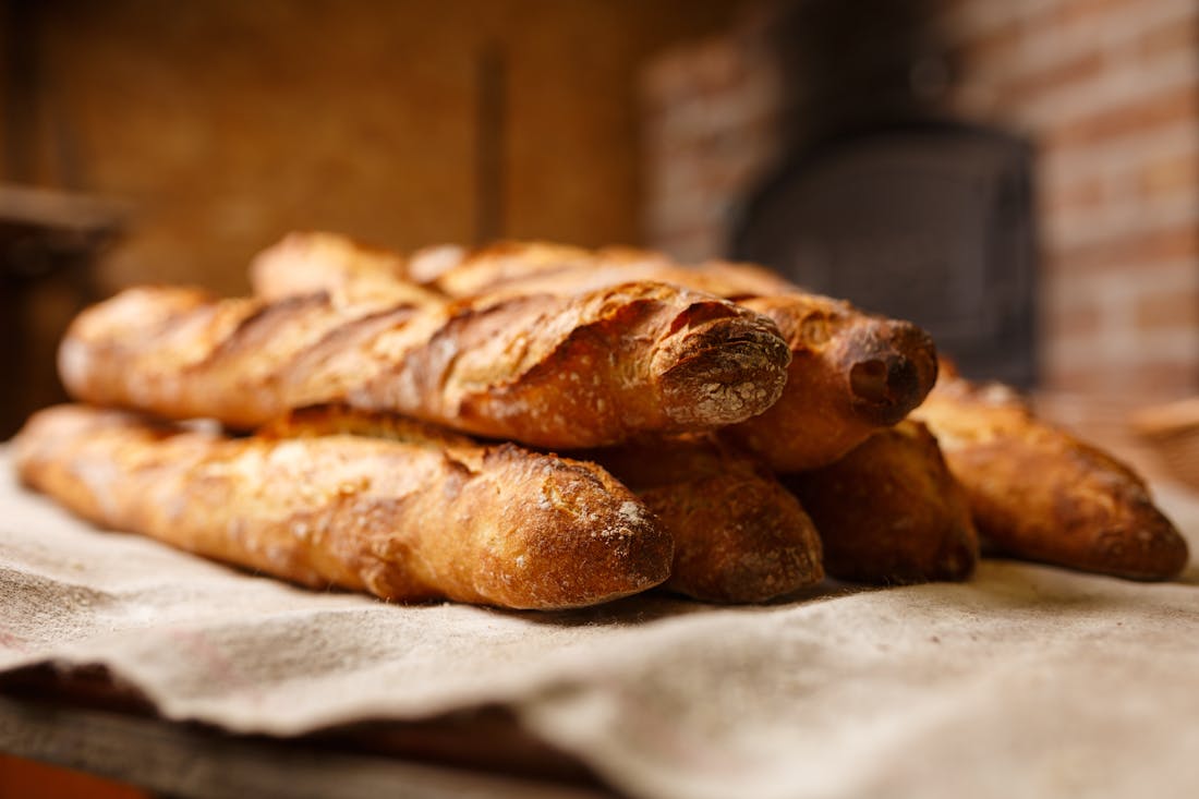 Fresh baguettes coming out of a bakery oven